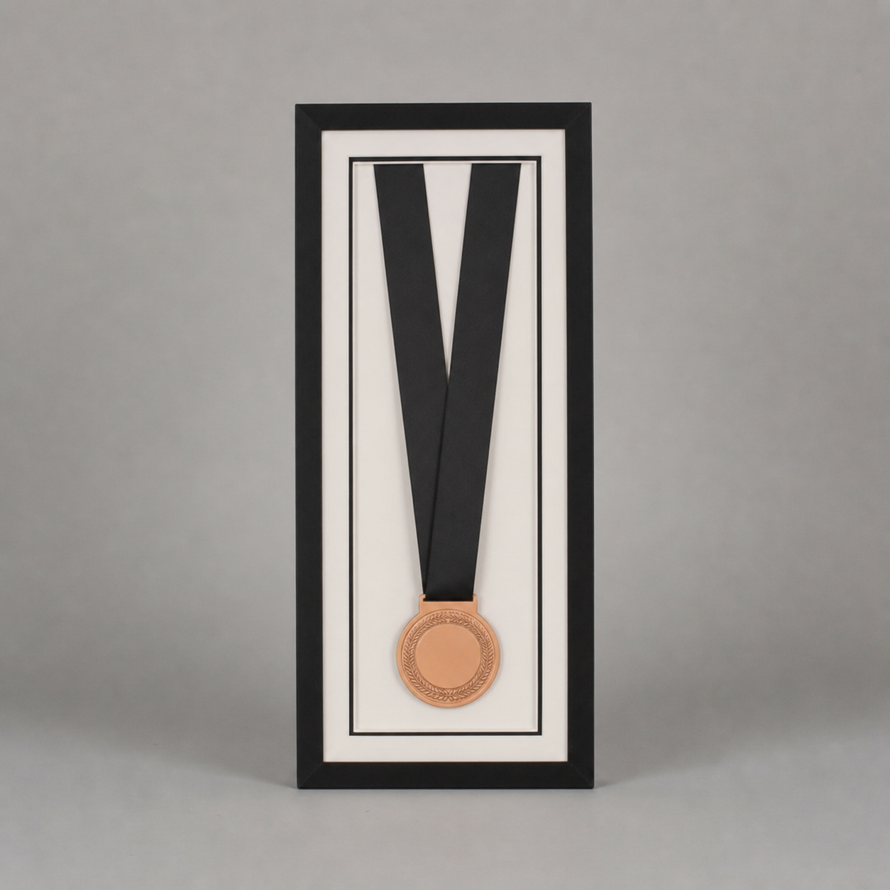 a framed medal with a black ribbon, set against a plain gray background.