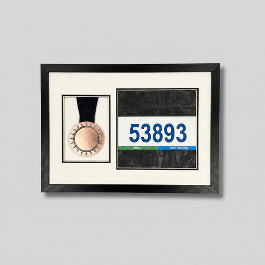 a framed display with a medal and a race number.