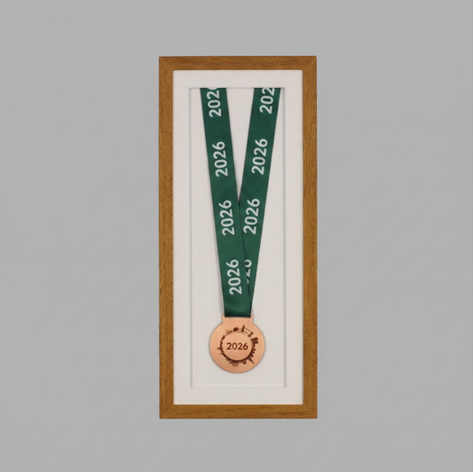 a framed medal with a green ribbon and a copper-colored medal with the year "2026" on it.
