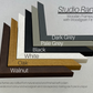 a collection of various colored wooden frames, each with a different finish, arranged in a visually appealing manner.