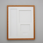 A white picture frame with a brown border is hanging on a gray wall.