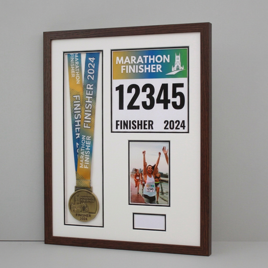 a framed display with a gold medal, a photo of a runner, and text related to the marathon finish.